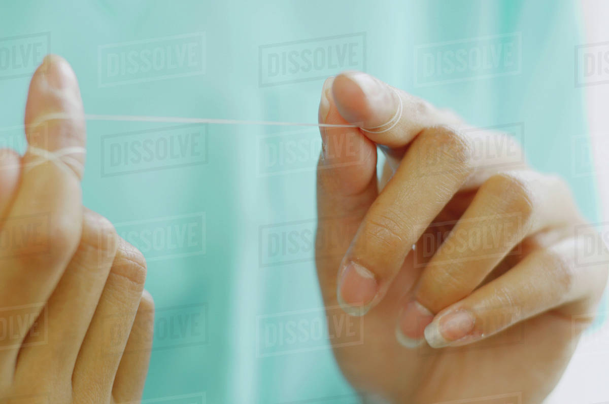 Close up of woman's hands with dental floss Stock Photo Dissolve