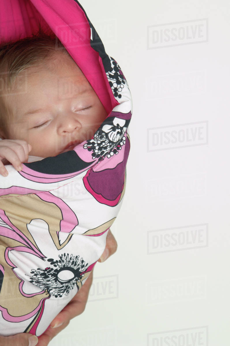 Hispanic baby sleeping in wrap Stock Photo Dissolve
