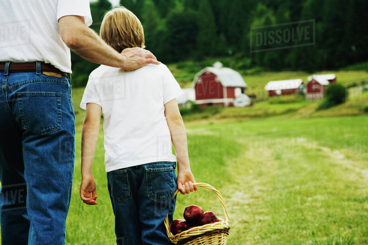 Father and son walking on farm - Royalty-free Stock Photo | Dissolve