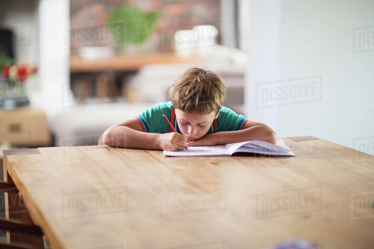 Caucasian boy drawing at table - Stock Photo - Dissolve