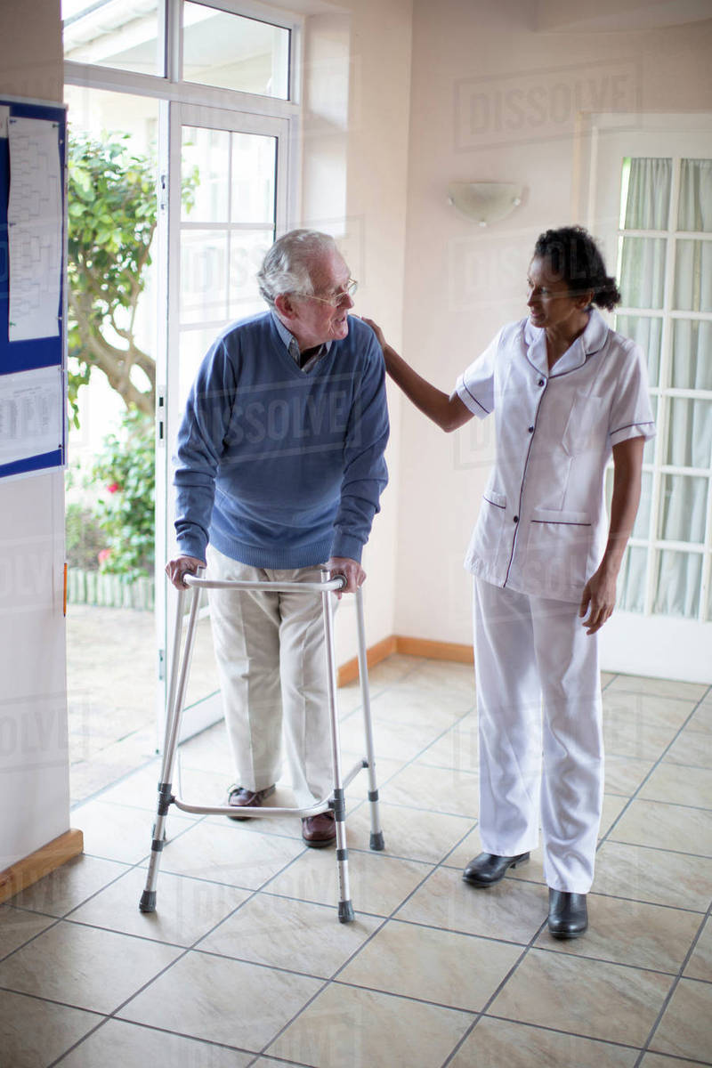 Nurse talking to patient using walker Stock Photo Dissolve