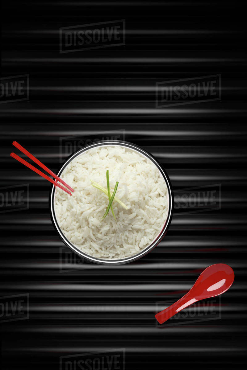 Chopsticks in bowl of white rice with red spoon - Royalty-free Stock ...