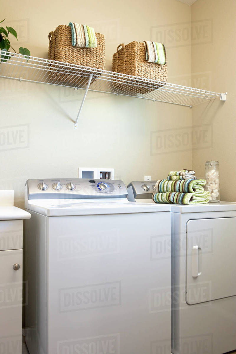 Towels folded on dryer in laundry room, Tustin, California, USA Stock