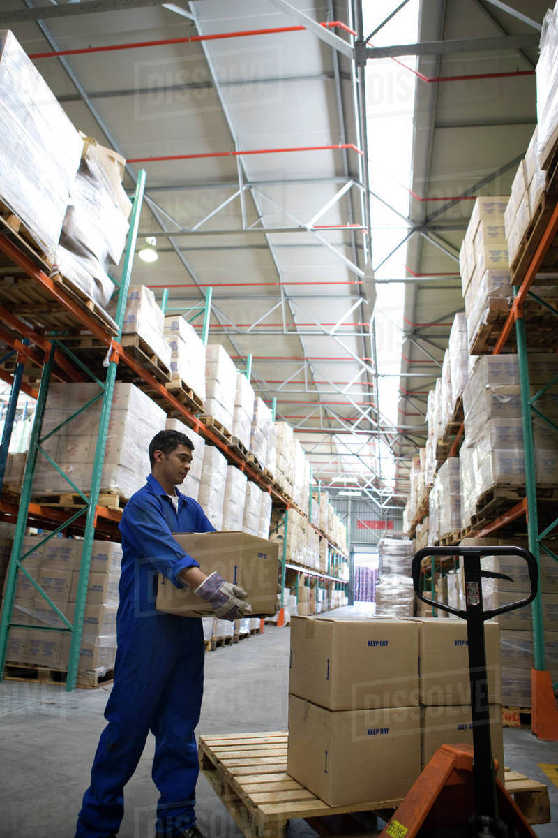 Worker stacking boxes in warehouse Stock Photo Dissolve