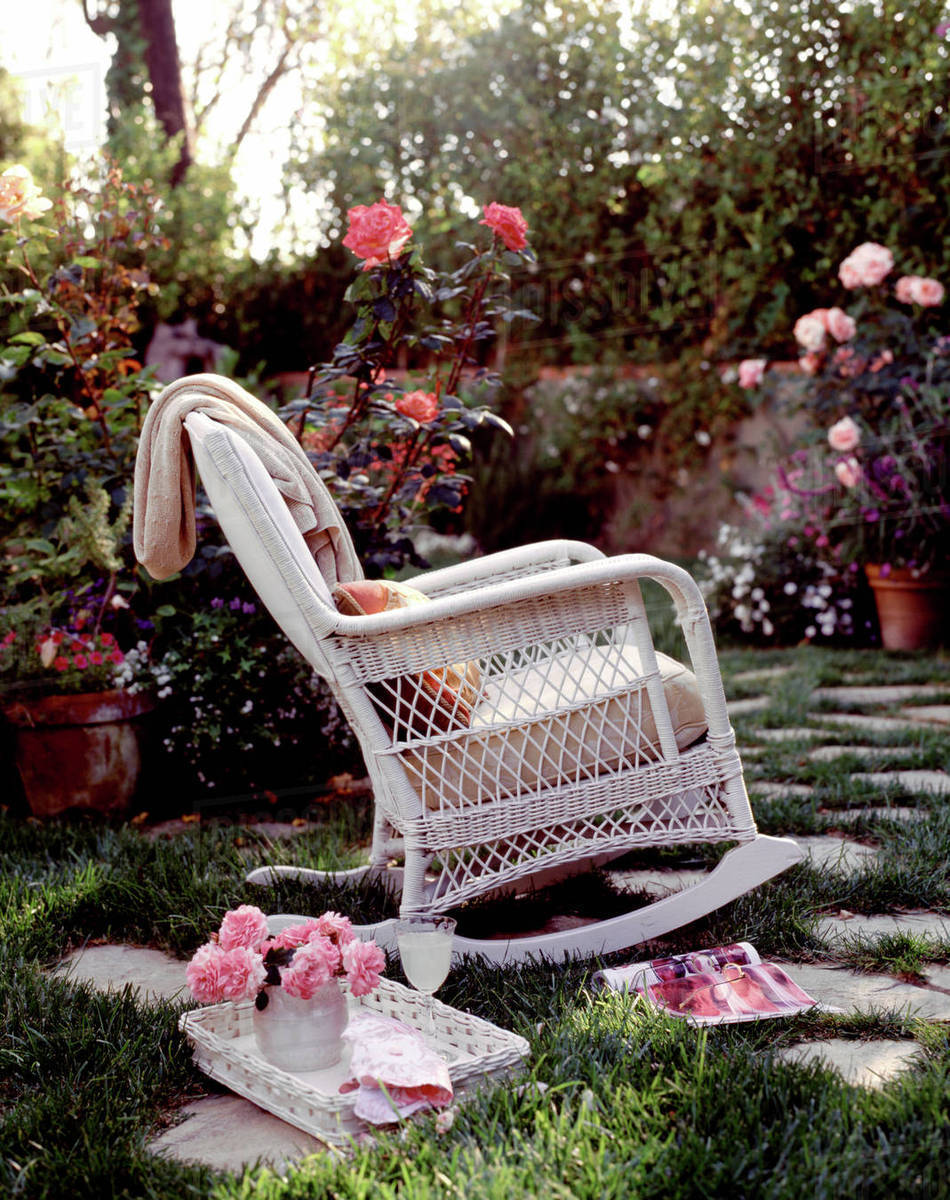Rocking chair and drinks in blooming garden Stock Photo Dissolve