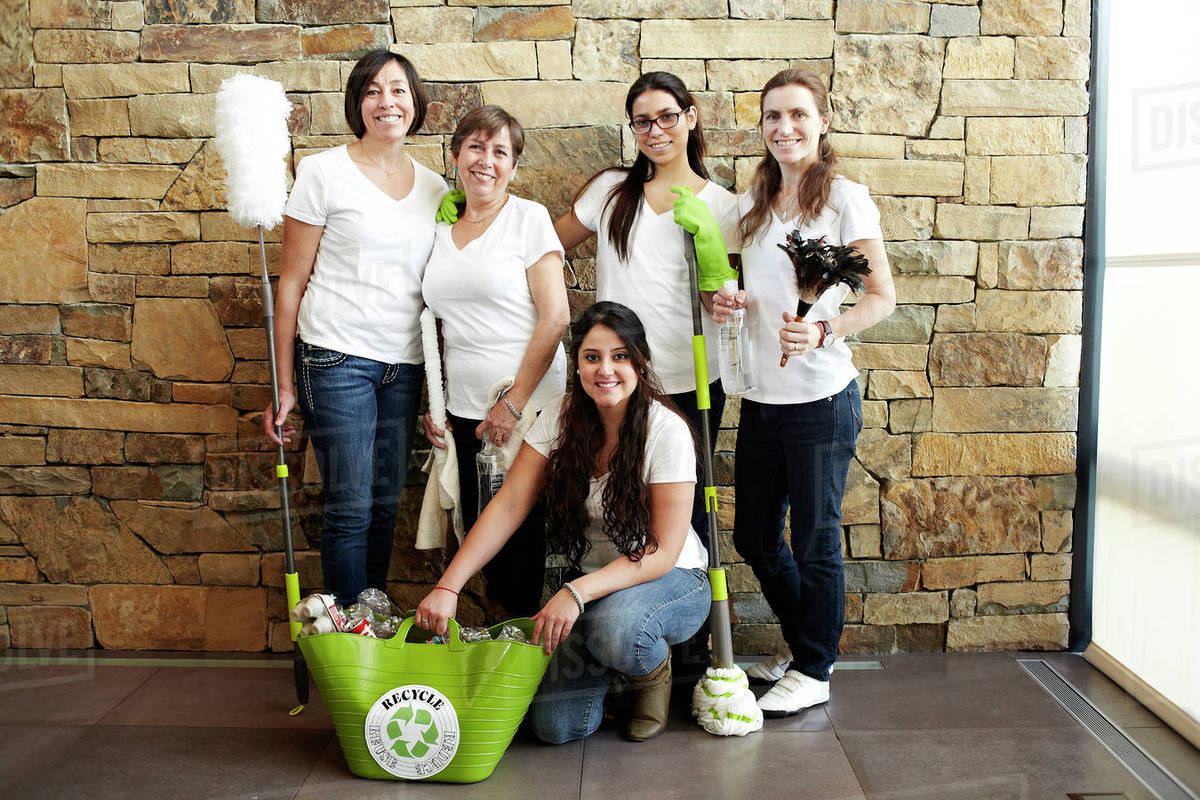 Hispanic cleaning crew smiling together Stock Photo Dissolve