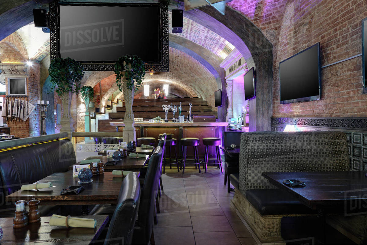 Sports bar and restaurant interior with screen and TVs on walls Stock