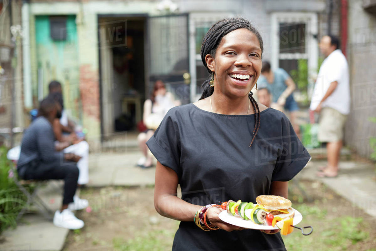 African American woman eating at backyard barbecue Royalty-free