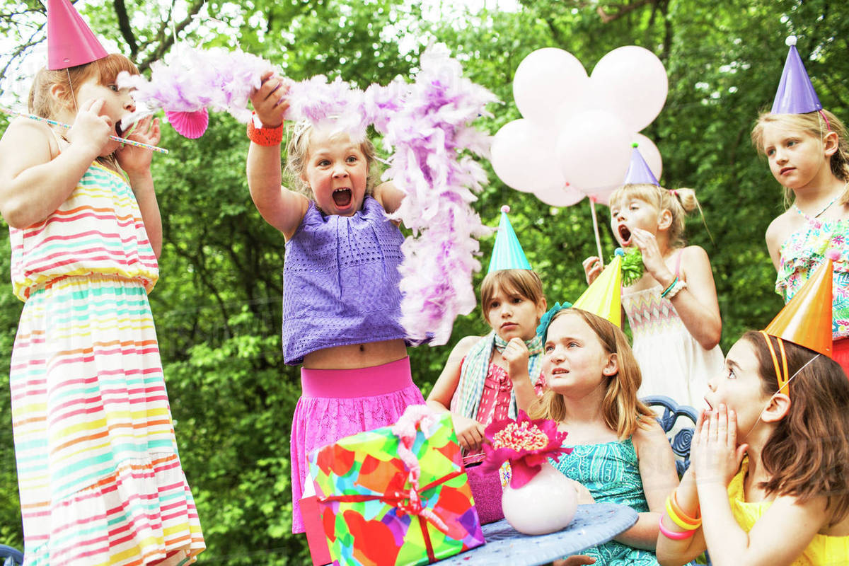 Girls cheering at birthday party outdoors Stock Photo Dissolve