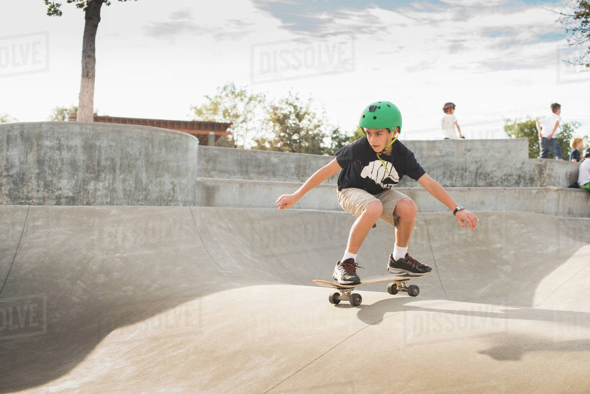 Mixed Race boy skateboarding in skate park Stock Photo Dissolve