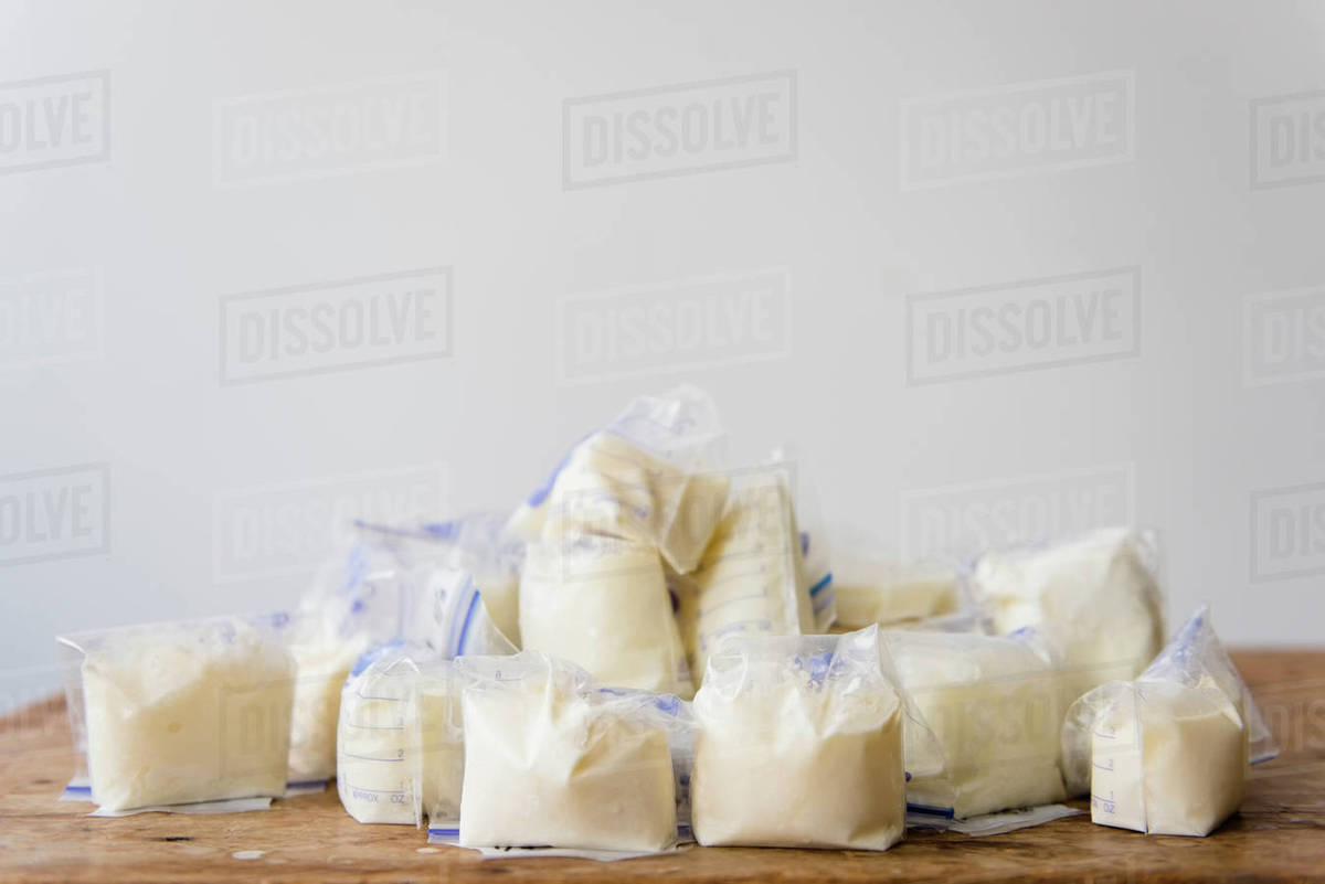 Bags of frozen breast milk on table Stock Photo Dissolve