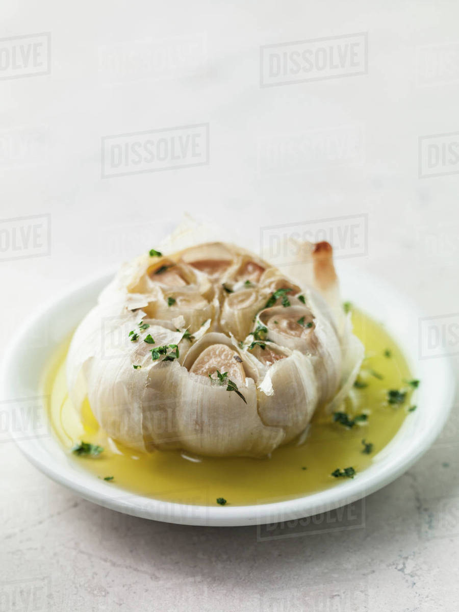 Roasted garlic in olive oil Stock Photo Dissolve