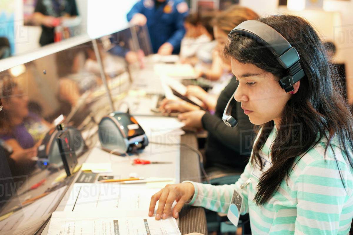 Hispanic student listening to headset at desk Royalty-free stock photo