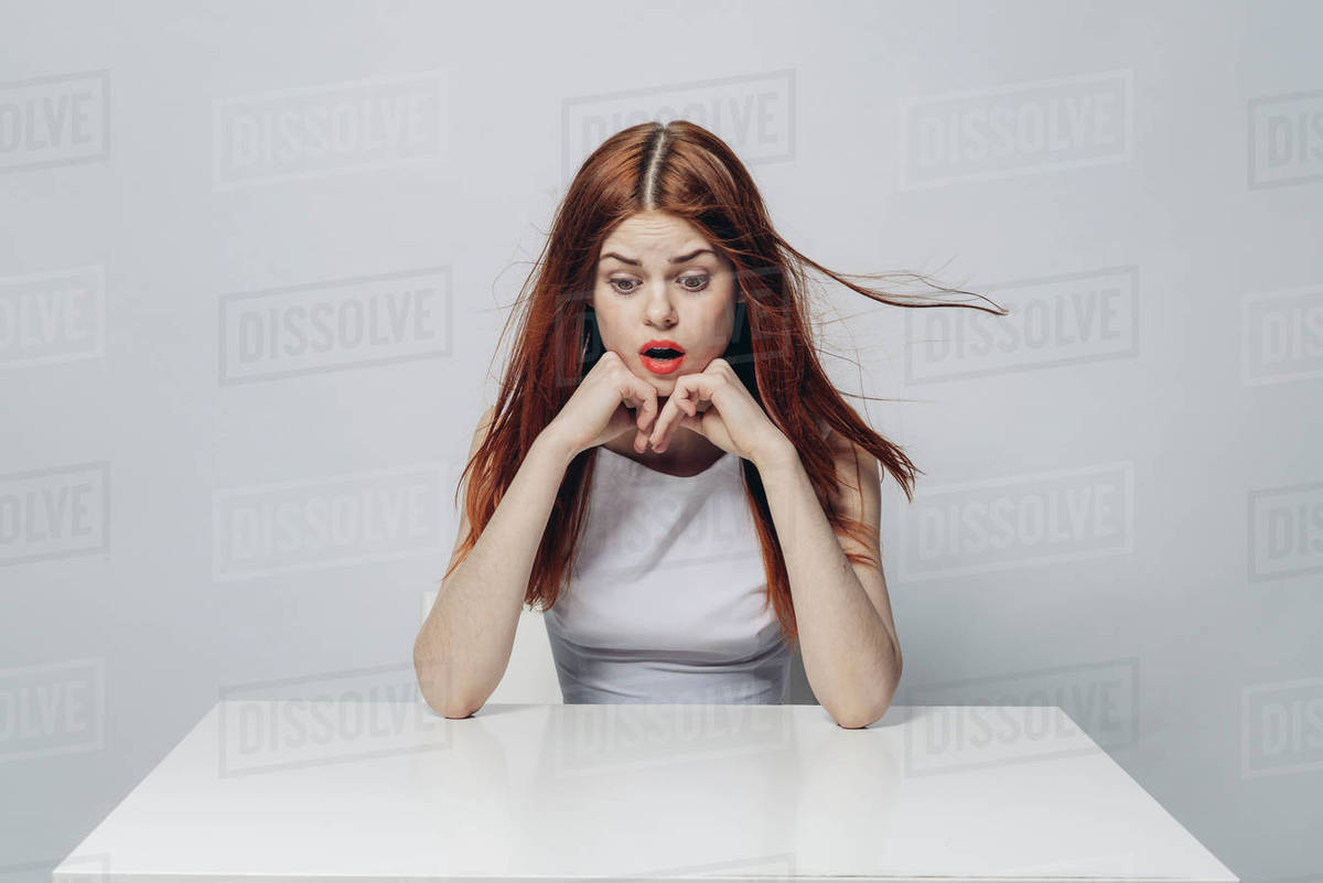 Surprised Caucasian woman sitting at windy table - Royalty-free Stock ...