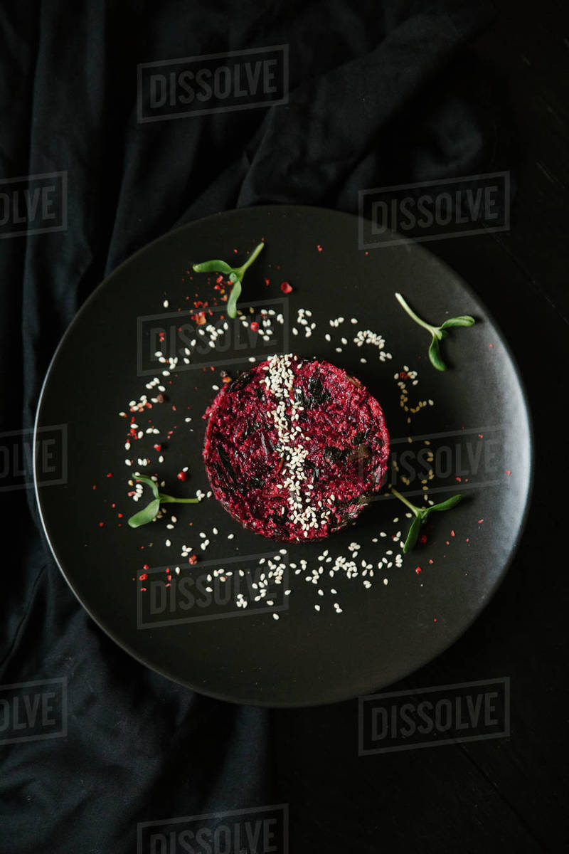 Sesame seeds and garnish on red food on plate Stock Photo Dissolve