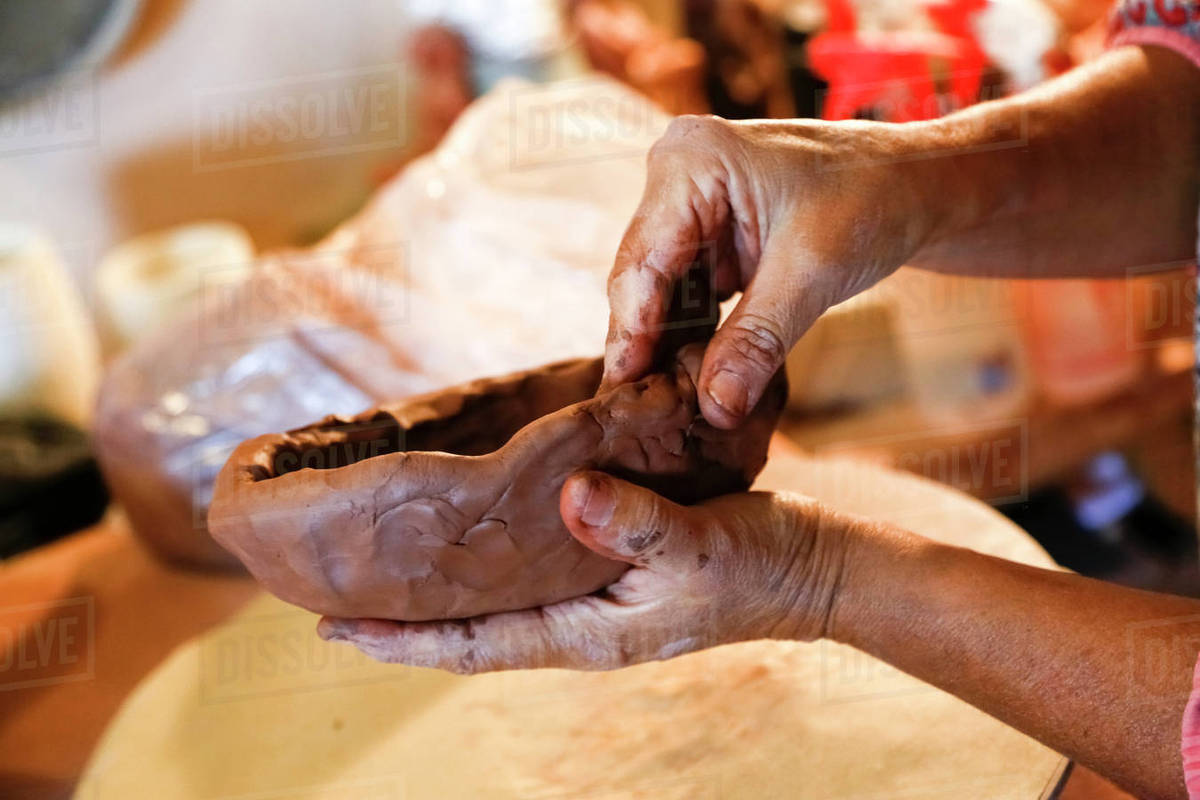 Hands of mixed race woman shaping clay in art studio Stock Photo