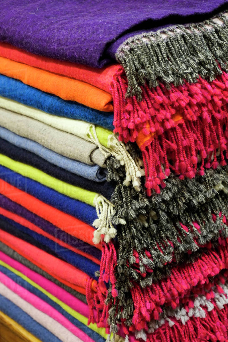 Piles of multicolor blankets with fringe Stock Photo Dissolve