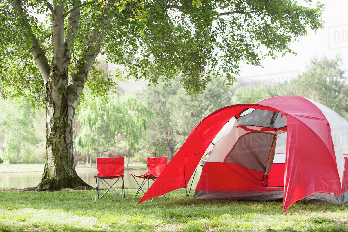 Lawn chairs and tent at campsite Stock Photo Dissolve