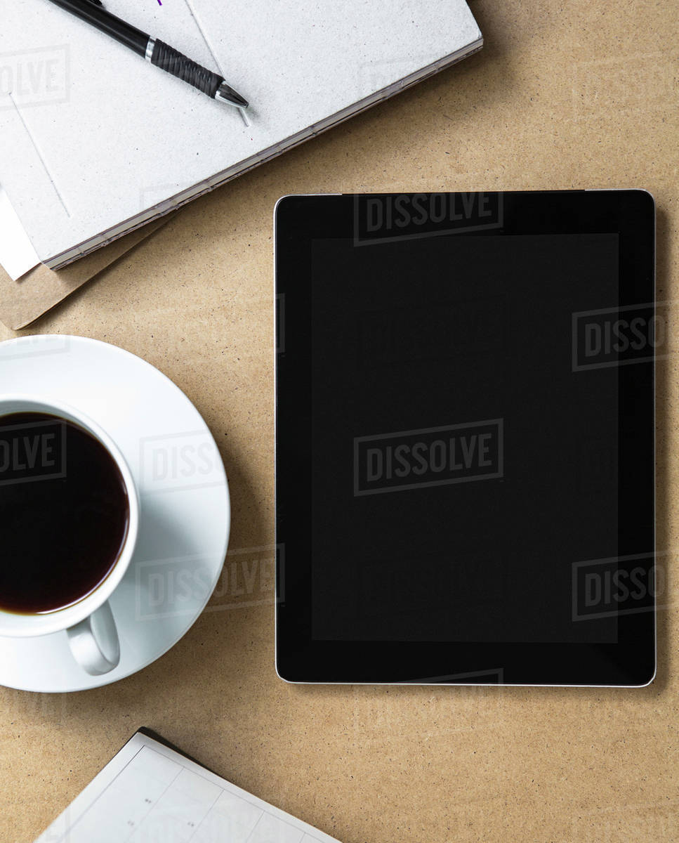 Tablet computer on table with book and coffee - Stock Photo - Dissolve