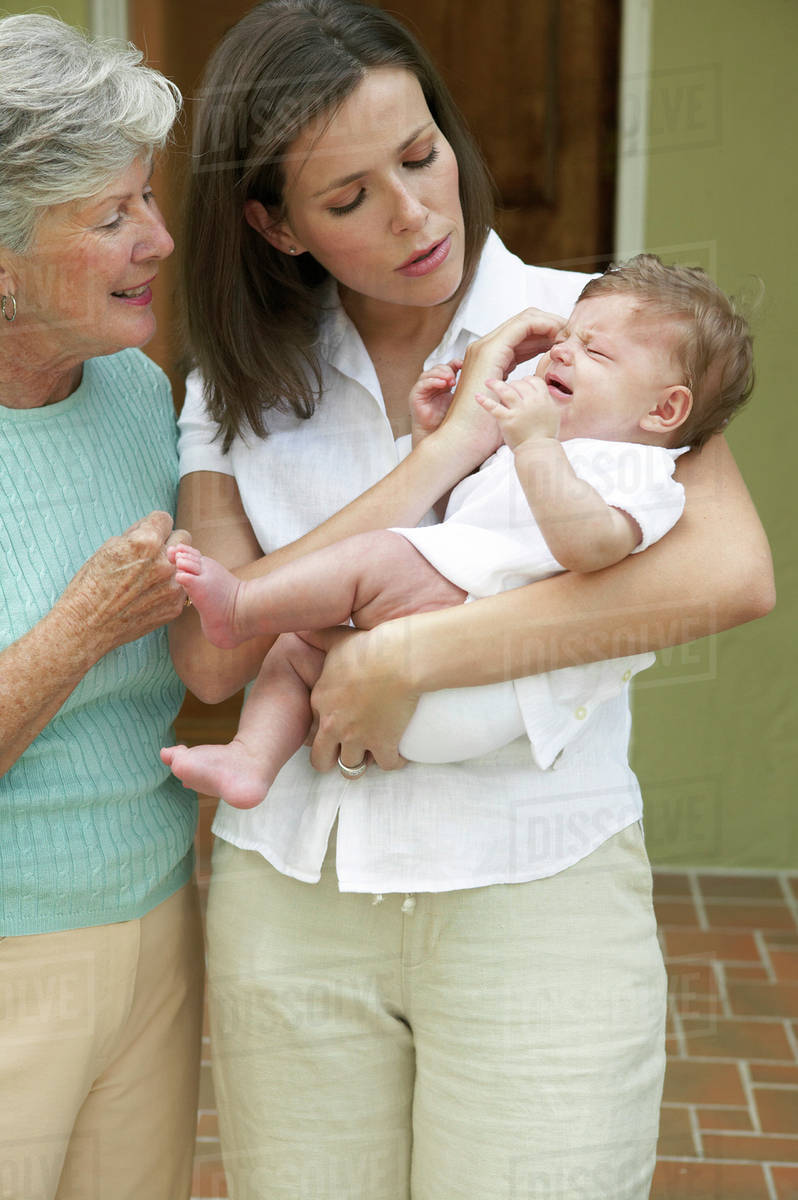 Mother And Daughter Comforting Crying Baby Stock Photo Dissolve