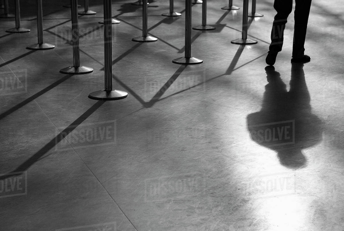 Shadow of man and ropedoff barriers Stock Photo Dissolve