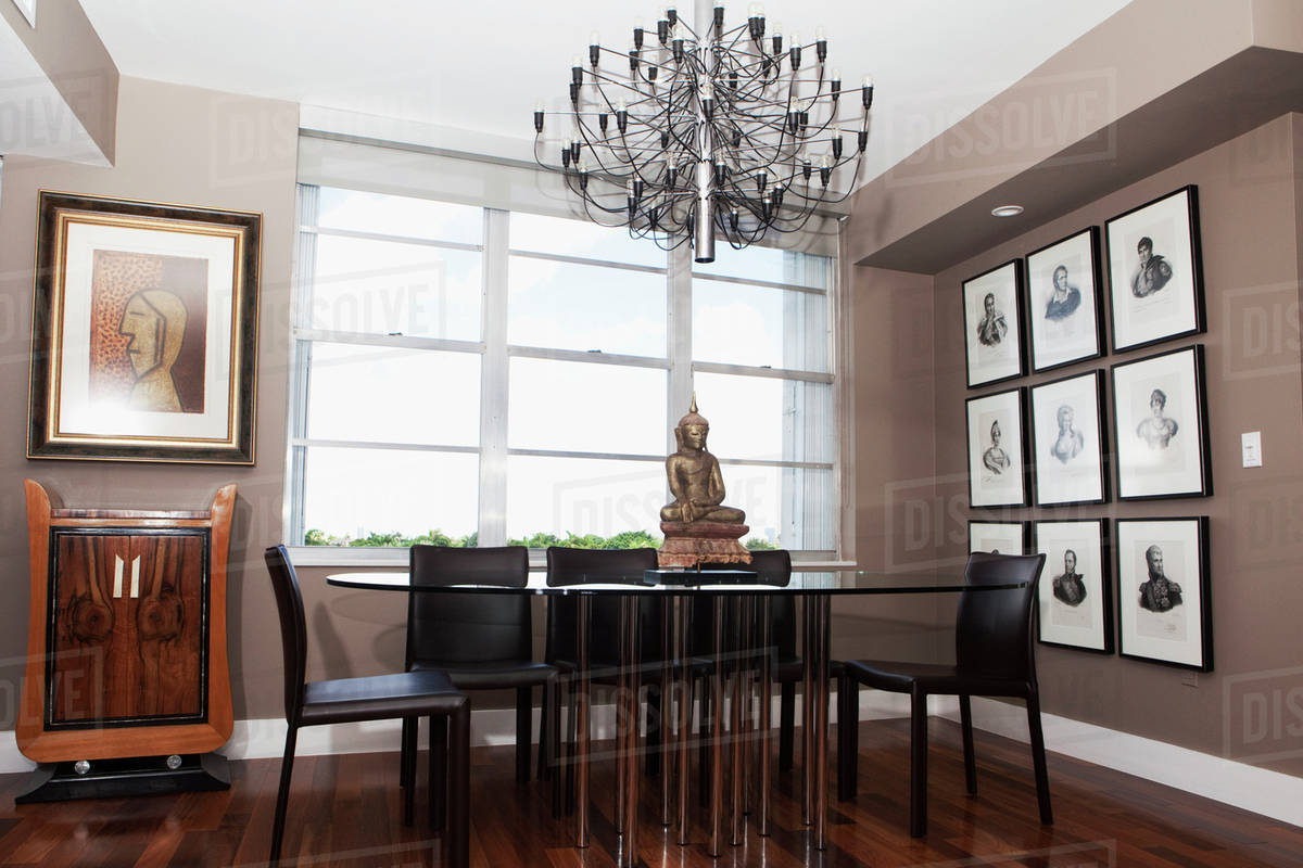 Chandelier over table in modern dining room Stock Photo Dissolve