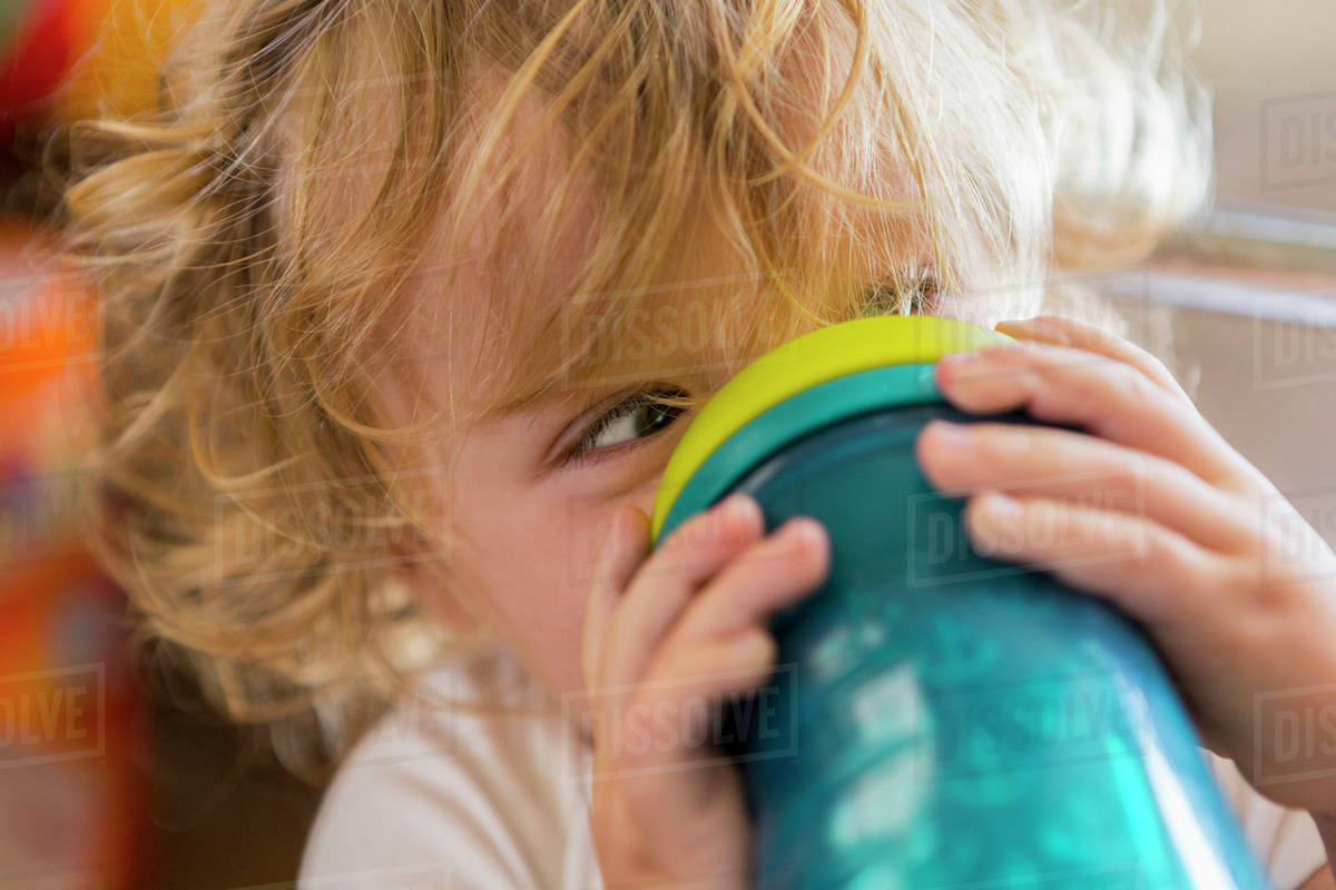 Caucasian baby drinking water from cup Stock Photo Dissolve