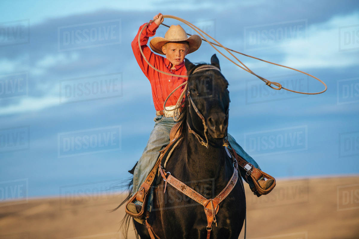 Caucasian boy on horse throwing lasso Stock Photo Dissolve