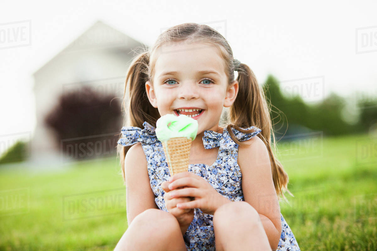 Caucasian girl eating ice cream outdoors Stock Photo Dissolve