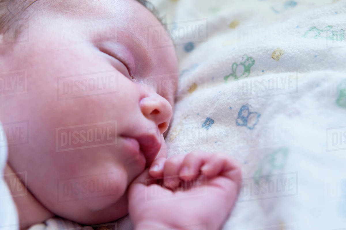 Caucasian newborn sleeping on bed Stock Photo Dissolve
