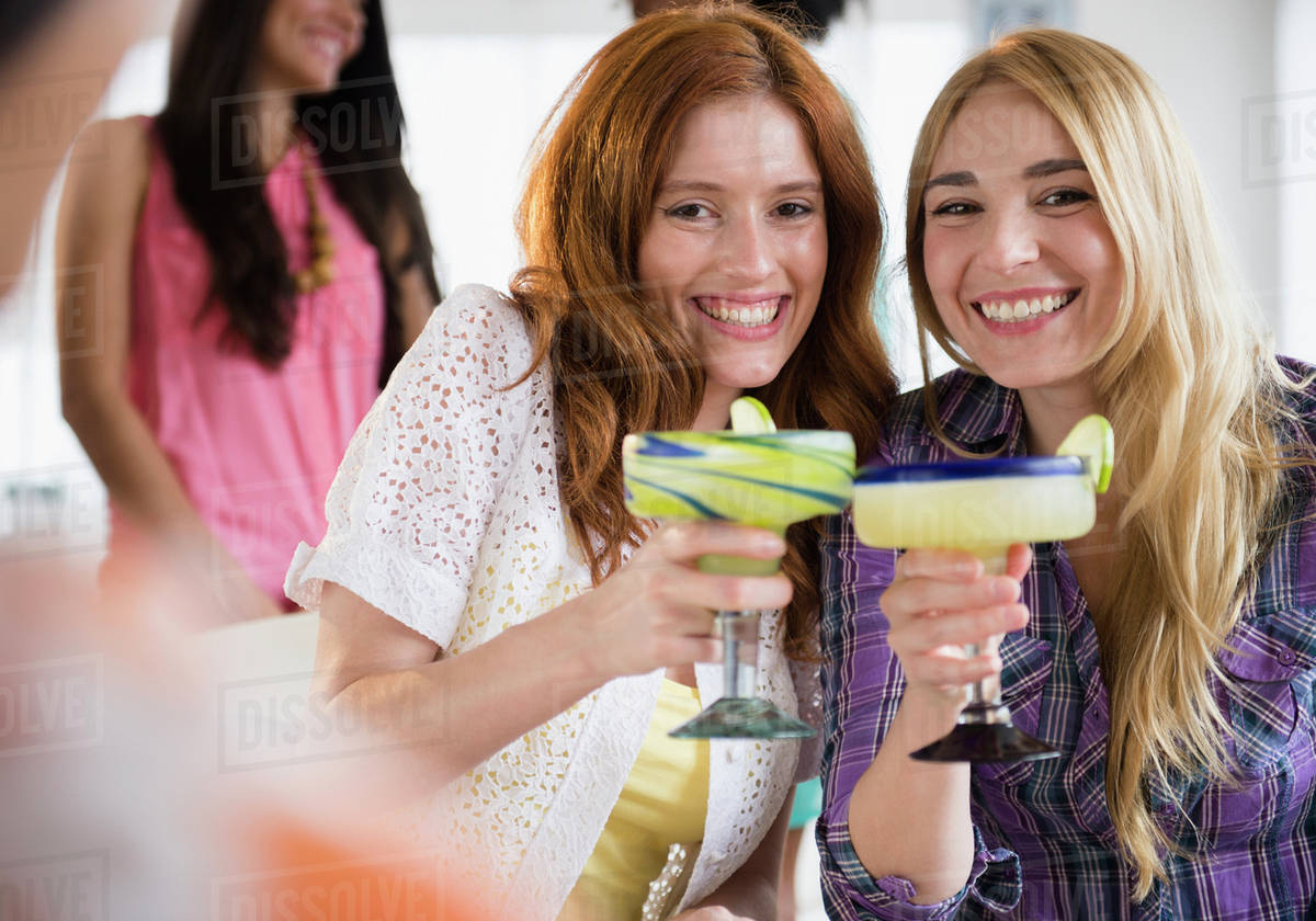 Women toasting each other with margaritas Stock Photo Dissolve