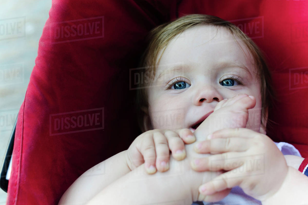 Caucasian baby boy chewing his toes Stock Photo Dissolve