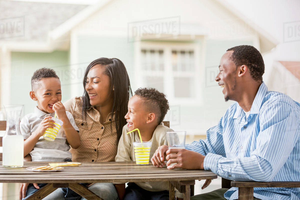 Family drinking juice in backyard Stock Photo Dissolve