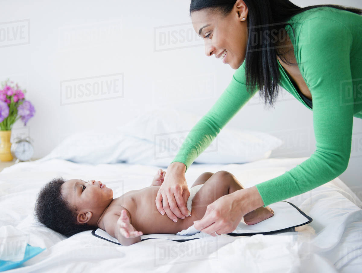 African American mother changing son's diaper Stock Photo Dissolve