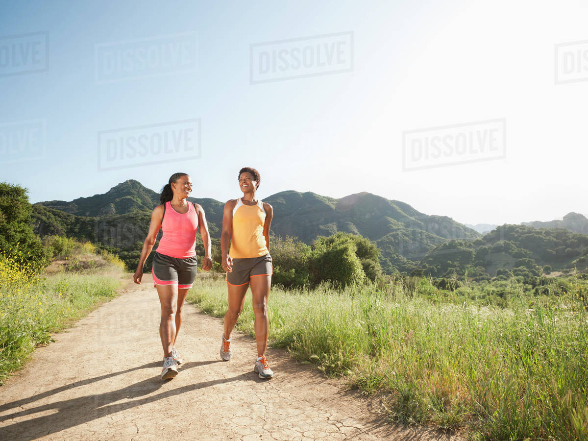 Athletic women walking together on remote trail - Stock Photo - Dissolve