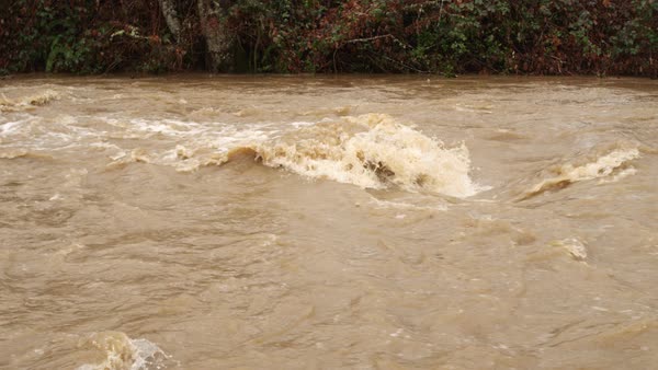Turbulent muddy water churns in a flooding creek - Stock Video Footage ...