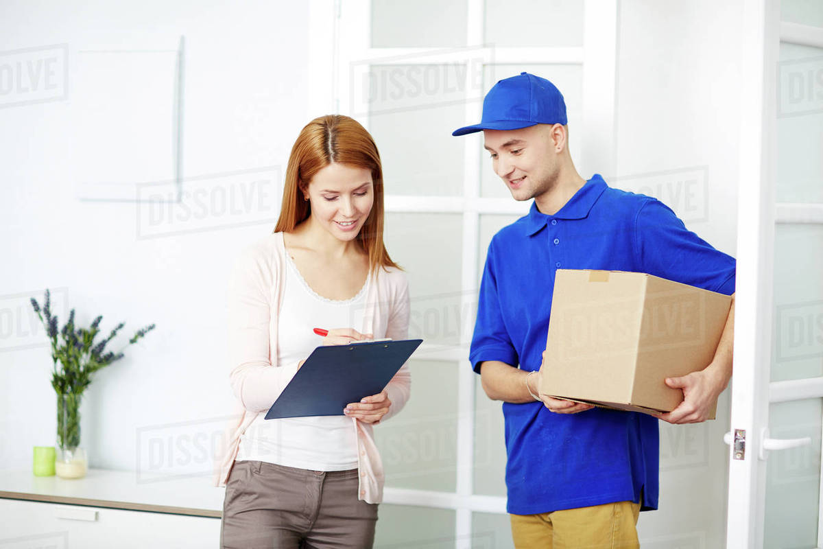 young delivery man looking at attractive young woman signing for