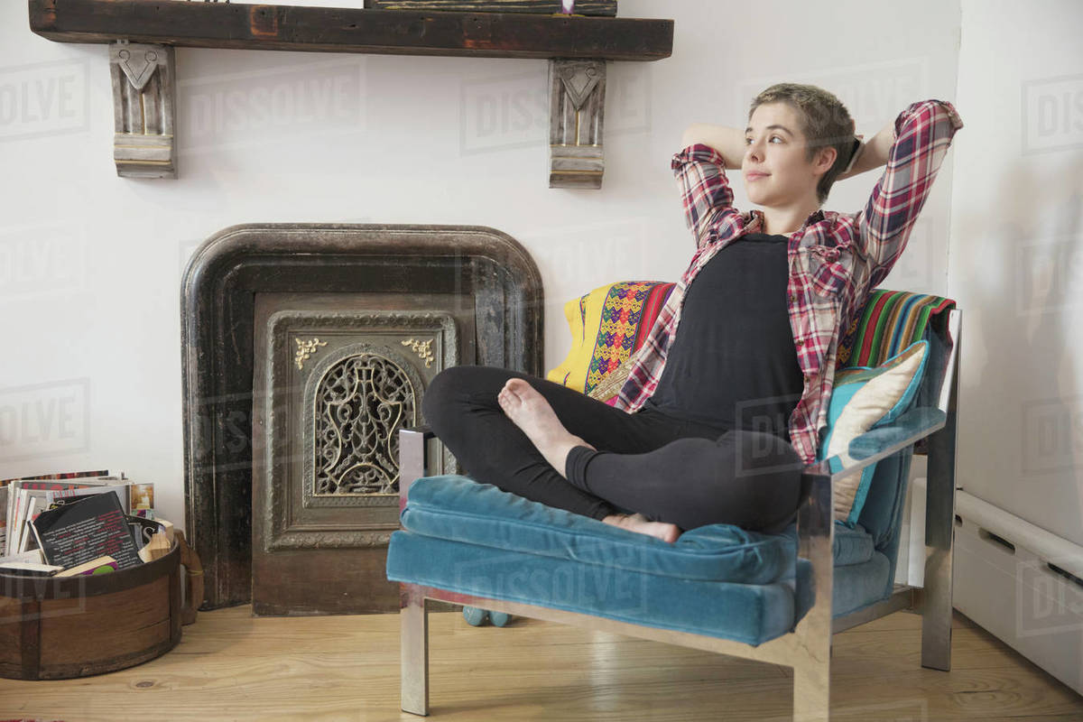 Transgender person relaxing in their armchair Stock Photo Dissolve