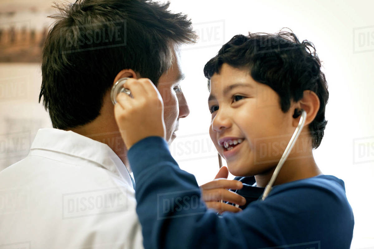 Little boy listening to his doctor's head with the stethoscope. Royalty-free stock photo