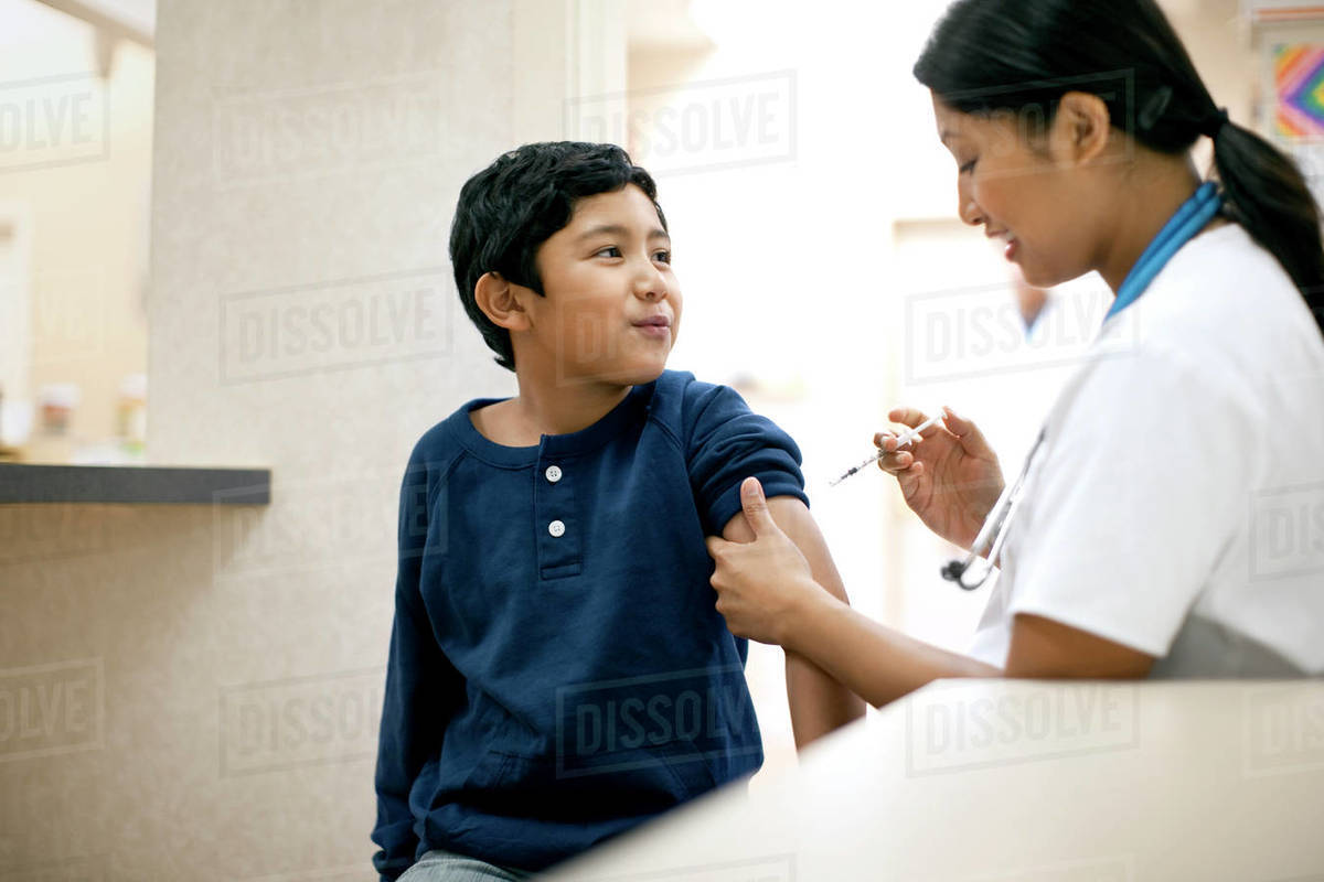 Nurse giving vaccine to her young patient. Royalty-free stock photo