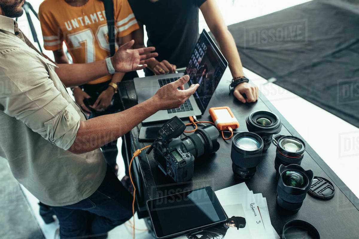 Photographer reviewing the photos of the shoot with his team on a