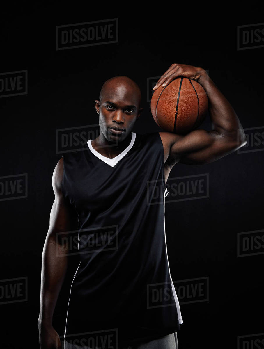 Portrait of professional basketball player holding the ball on his