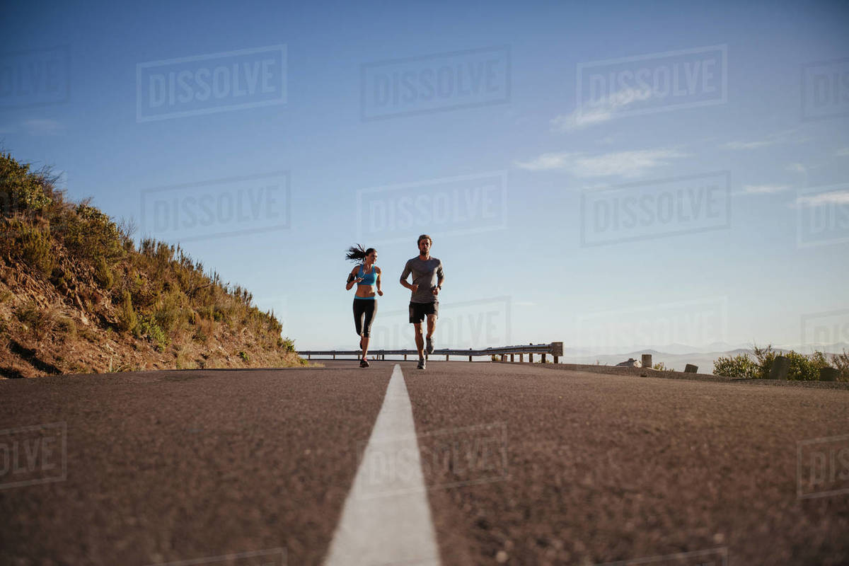 Low angle view of two young people running on Young couple