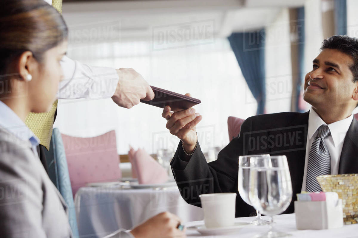 Businessman paying the check at restaurant Stock Photo Dissolve