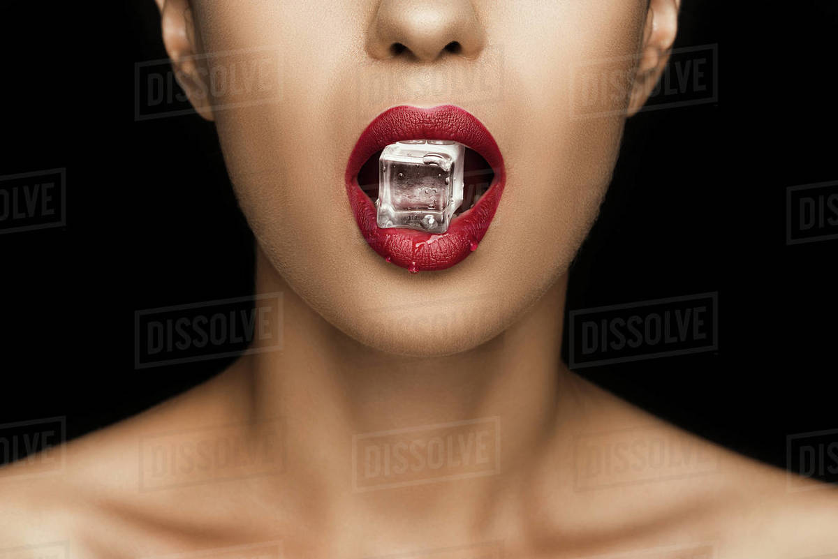 Cropped view of seductive woman with red lips holding ice cube in mouth