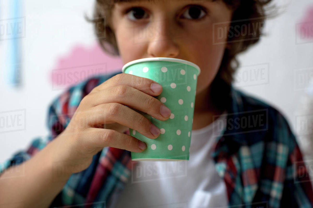 closeup view of cute little boy drinking from paper cup Stock Photo