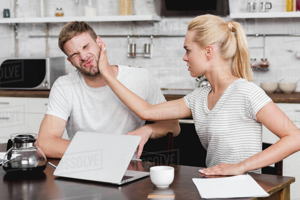 young woman slapping boyfriend during quarrel at home Stock Photo