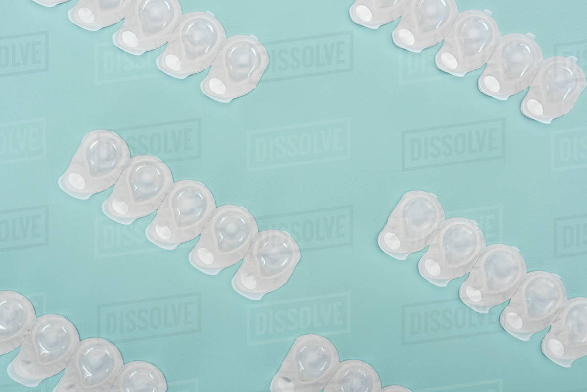 Top view of contact lenses in containers arranged on blue background