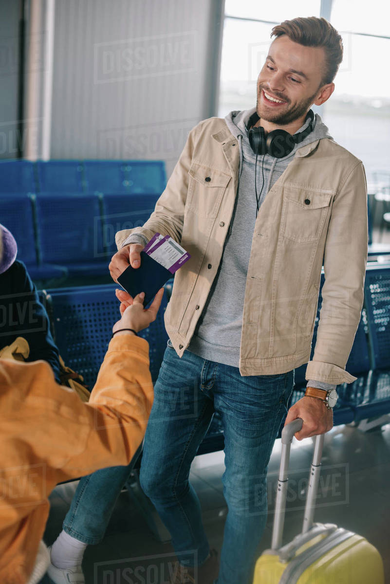 Cropped shot of friends holding passport with boarding passes while