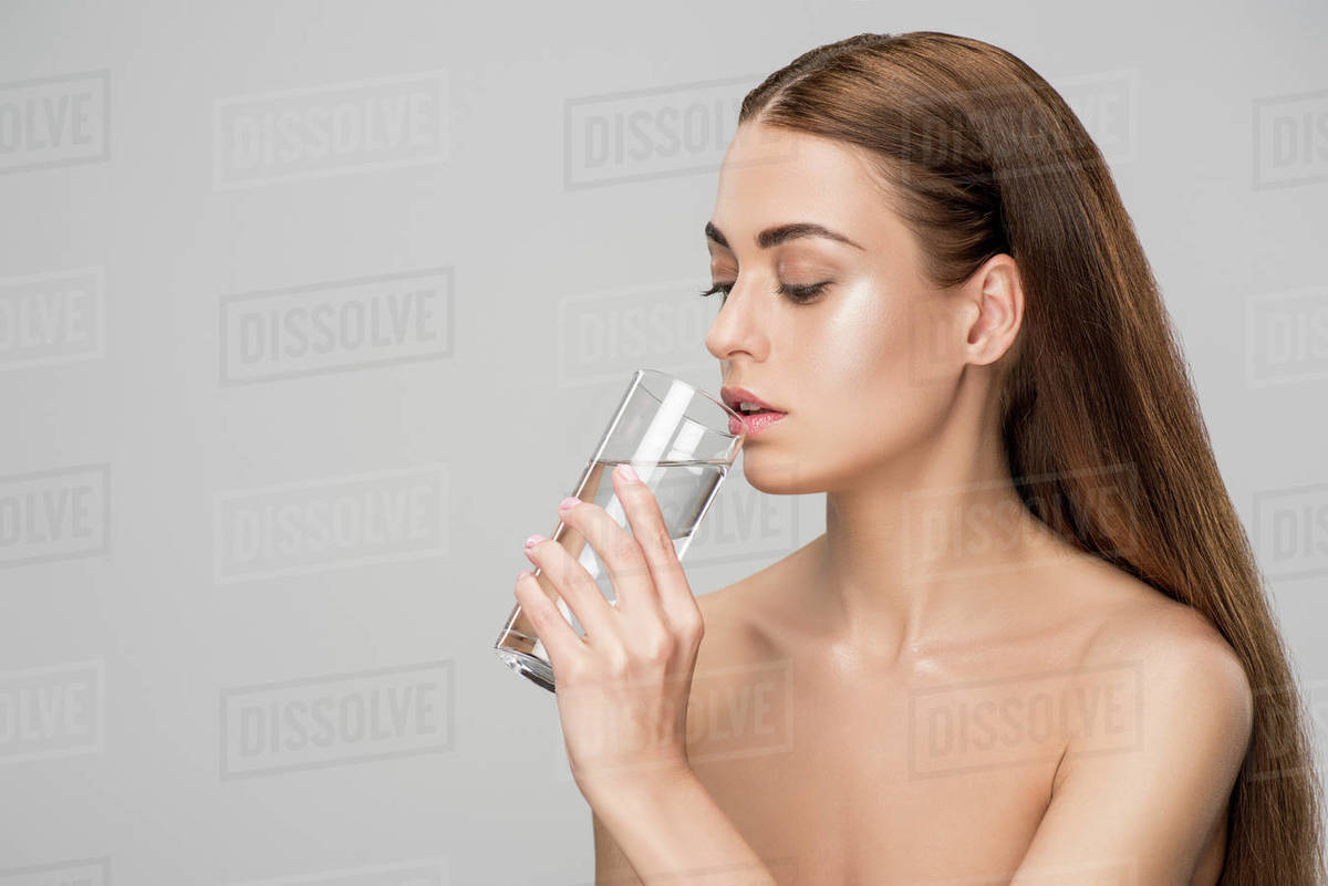 Drunking nudist-woman Beautiful naked woman drinking pure water isolated on grey - Stock Photo - Dissolve